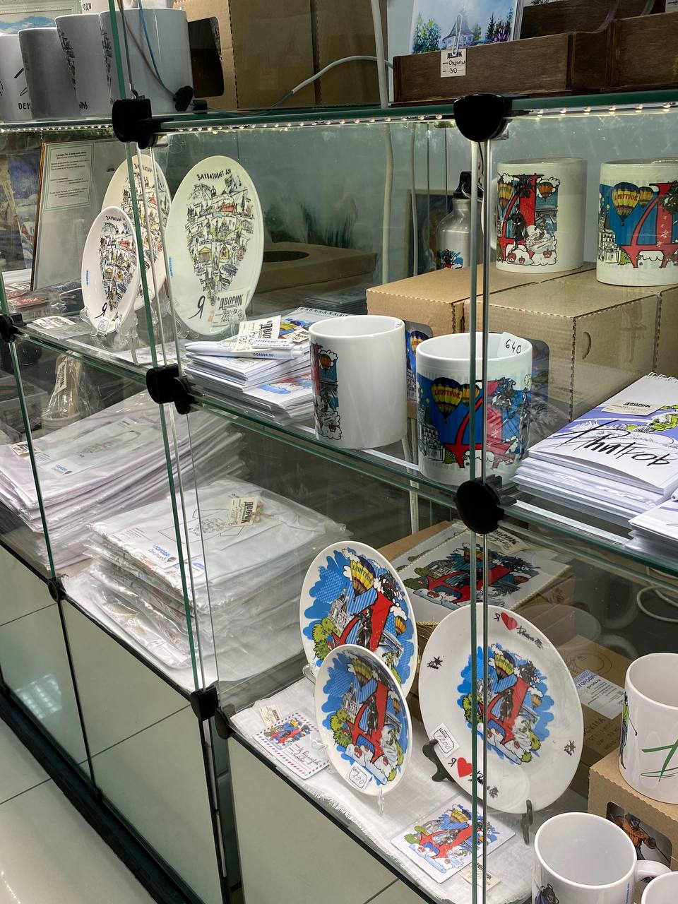 Тарелки, кружки и футболки на витрине сувениров Дмитрова